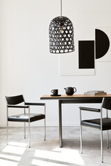 Stylish dining room interior with design wooden family table, black chairs, teapot with mug, mock up art paintings on the wall and elegant accessories in modern home decor. Template.