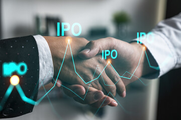 Multiexposure of two businesspeople handshake and initial primary offering, IPO hologram drawing...
