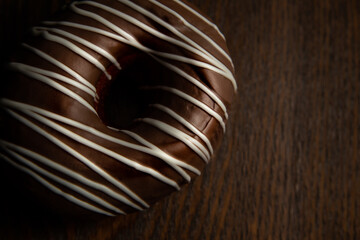 Donut com chocolate ao leite e decorado com chocolate branco.