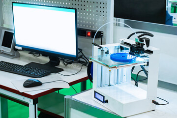 Modern equipment in the office. 3D printer and computer. Printer for printing three-dimensional models. Device for layer-by-layer printing of volumetric objects. Modern technology.