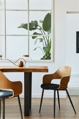 Stylish and botany interior of dining room with design craft wooden table, chairs, a lof of plants, window, poster map and elegant accessories in modern home decor. Template.