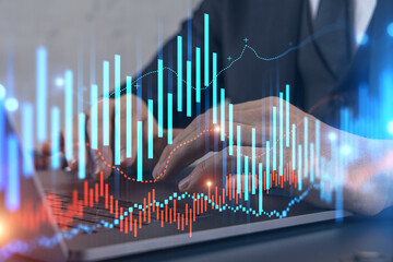 Businessman trading on-line, typing laptop background and forex graph hologram.