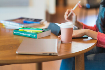 Close up hand of Asian woman in pink sweater use tablet for e-learning