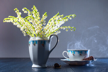 Spring still life with lilies of the valley and a snail. A bouquet of lilies of the valley, a Cup...