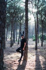 Fototapeta premium Chico joven con mascara de conejo negro en un bosque