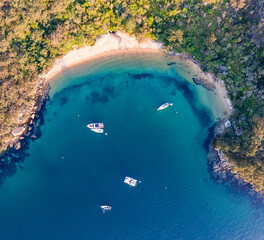 Aerial drone bird's eye view of sailboats and yachts anchored at Store Beach near Quarantine...