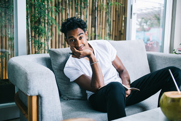 Young man with pen and notebook relaxing on sofa