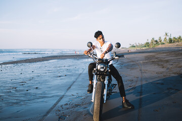 Hispanic male biker starting motorcycle engine