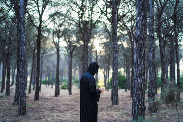 Fototapeta na wymiar Chico disfrazado de monje oscuro en halloween en un bosque