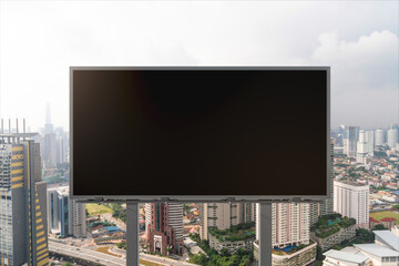 Blank black road billboard with Kuala Lumpur cityscape background at day time. Street advertising poster, mock up, 3D rendering. Front view. Concept of marketing to promote or sell services or ideas.