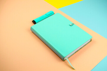 libreta color celeste sobre fondo de varios colores 
