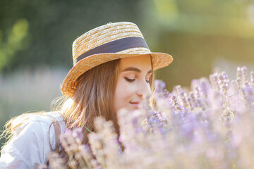 Beautiful young woman in the sunset light. Portrait of a beautiful woman in blooming lavender. Summer.
