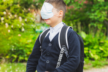 school child boy wearing medical face mask. preteen with school bag back to school after end coronavirus quarantine isolation Lockdown. new normal life. Close up portrait boy looking at camera