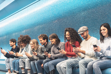 Happy friends using mobile smartphone in underground station - Young people having fun with new trends social media apps - Youth millennial generation lifestyle and technology addiction concept