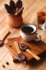 Spoon-Shaped Coffee Cookies dipped in dark chocolate, on a wooden table.