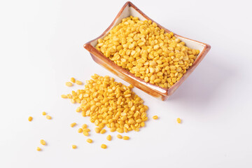 Hulled split mung bean in brown cup on white background