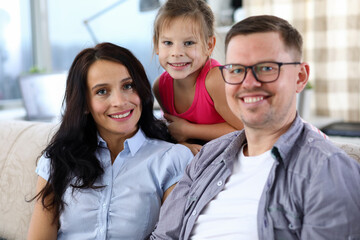 Cheerful parents with daughter at home