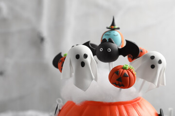 Different Halloween themed cake pops on light background, closeup