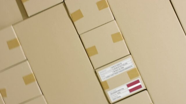 Cardboard box with printed MADE IN LATVIA text among other boxes 