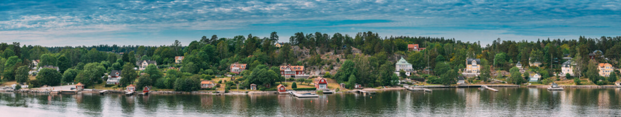 Sweden. Beautiful Red Swedish Wooden Log Cabin House On Rocky Island Coast In Summer Sunny Evening....