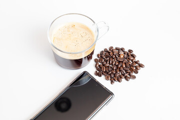 coffee grinder with coffee beans and black screen mobile phone on white background