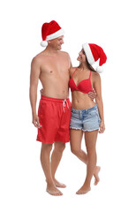 Obraz premium Happy couple with Santa hats together on white background. Christmas vacation