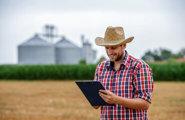 Farmer making a notes in the field. Agricultural concept