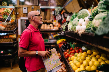 Elderly man standing at counter with vegetables