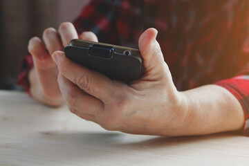 senior woman using smartphone, touching screen, typing message, chatting or using app, top view