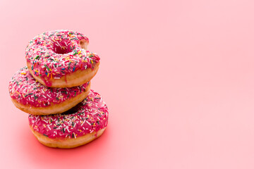 Pink berry donuts close up. Glazed and sprinkles bakery