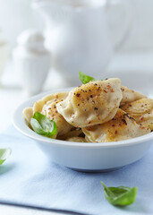 Dumplings with potato and cottage cheese stuffing (pierogi). Traditional Polish Christmas Dinner. Bright background.