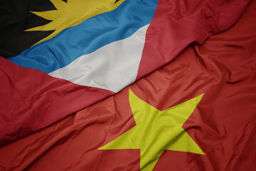 waving colorful flag of vietnam and national flag of antigua and barbuda.