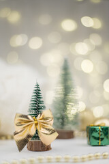 Little Christmas trees decorated and gifts for the new year on the bokeh background, new year composition