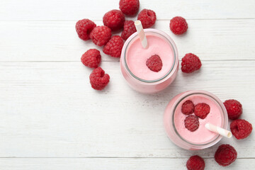 Yummy raspberry smoothie on white wooden table, flat lay
