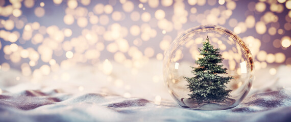Christmas tree in glass ball on snow. Glitter lights