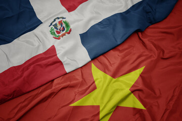 waving colorful flag of vietnam and national flag of dominican republic.