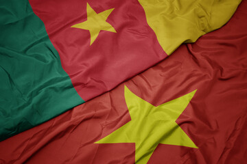 waving colorful flag of vietnam and national flag of cameroon.