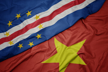 waving colorful flag of vietnam and national flag of cape verde.