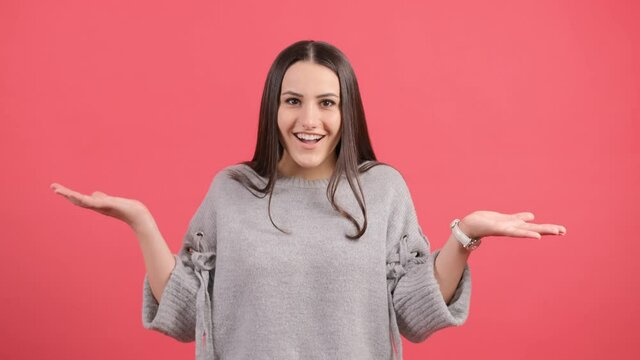 Don't know, sorry. Portrait of clueless uncertain girl, feeling confused unsure about answer, having doubts, smiling over red background.
