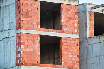 Building under construction, red bricks and concrete slabs