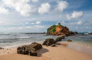 An island near Sri Lanka beach and a dilapidated stone wall leading to it