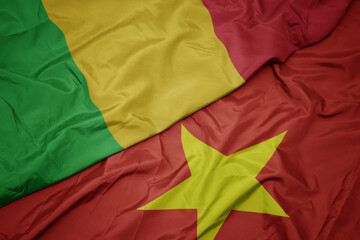 waving colorful flag of vietnam and national flag of mali.