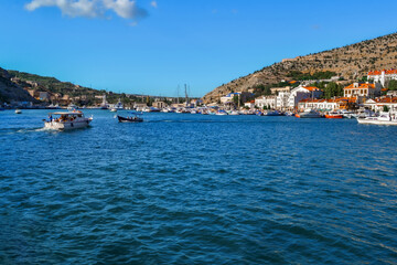 Fototapeta premium blue water with waves in bay of mountain town of Balaklava with marinas, white ships, boats and bright buildings, ripples, summer