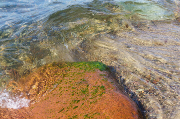 Sea stone under water. Crystal clear sea water transparent.