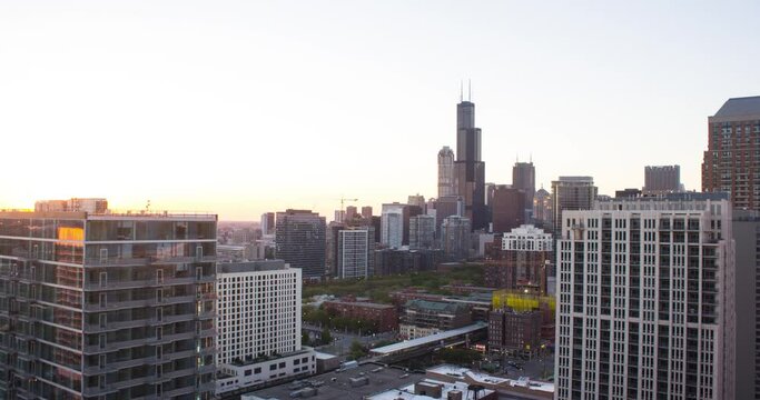 This a day to night time lapse of downtown Chicago. The Sears / Willis tower is visible in the background. As the sunsets, the skyline of Chicago is lit of lights.