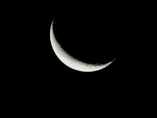 Fototapeta na wymiar a waning moon stands as crescent moon in the black night sky
