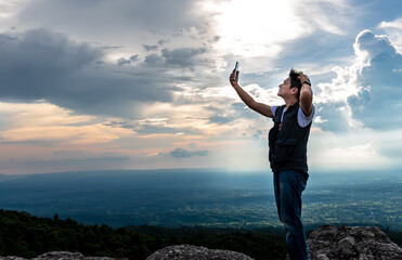 Asian men Are stressed From the absence of a cell phone signal, as he stood at the highest point on...