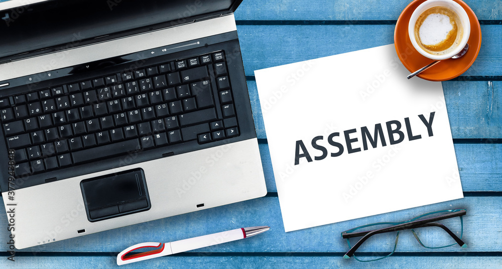 Poster assembly programming language. paper width word assembly and laptop, glasses and coffee on wooden ta