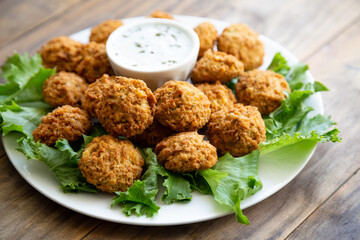 Homemade falafel with yogurt sauce on a wooden table