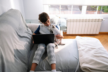 11 year old boy with laptop and dog at home
